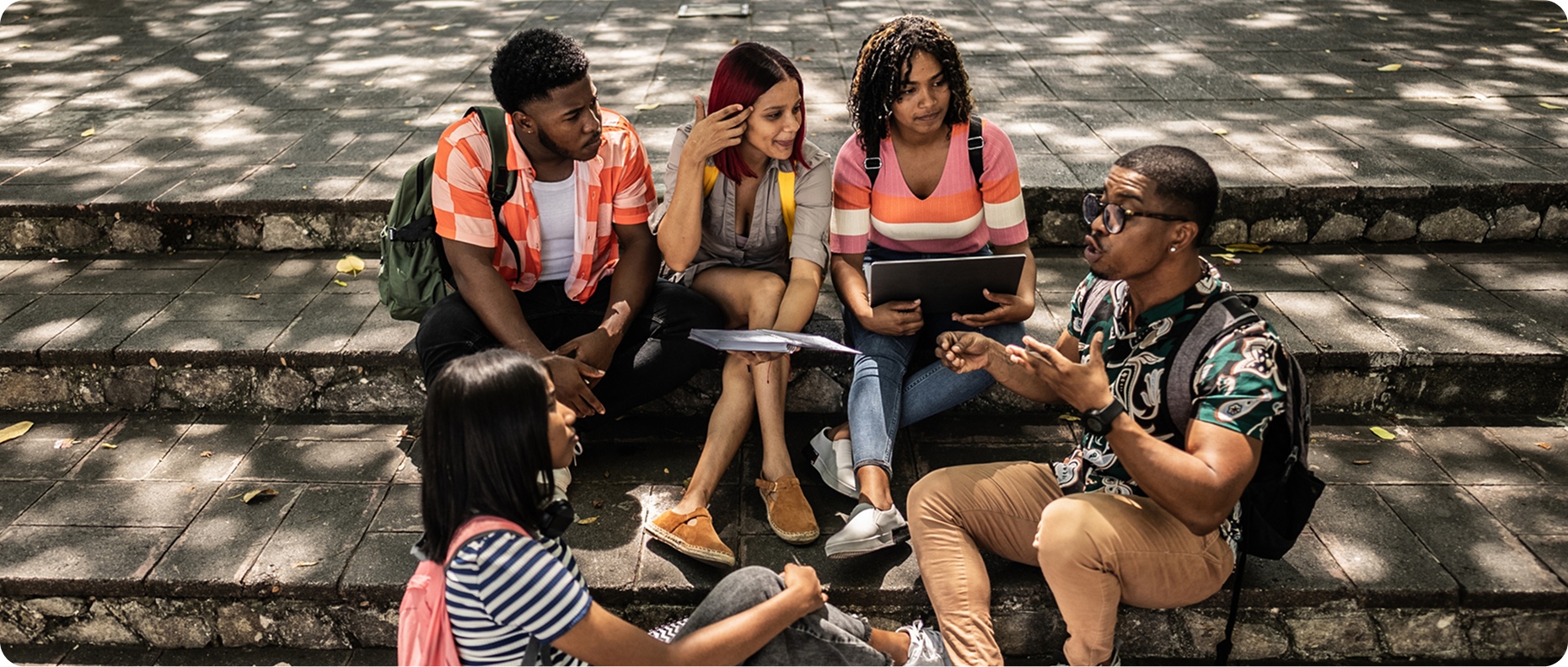 Friends chatting with laptops on steps